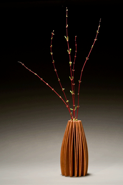 Cherry wood vase made from one piece of wood with glass tube in center