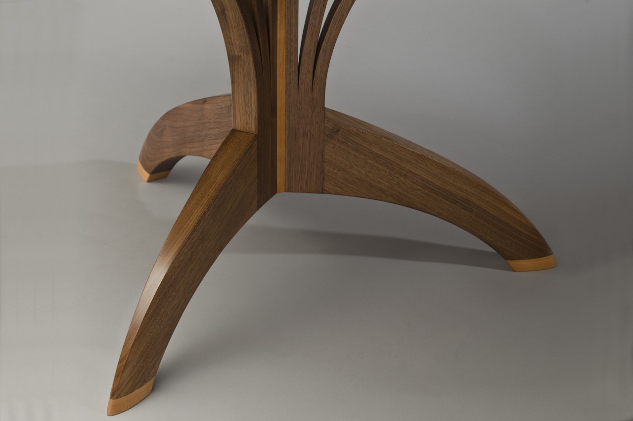 Detail of Arbol cafe table base in carved walnut and cherry by Seth Rolland custom furniture design