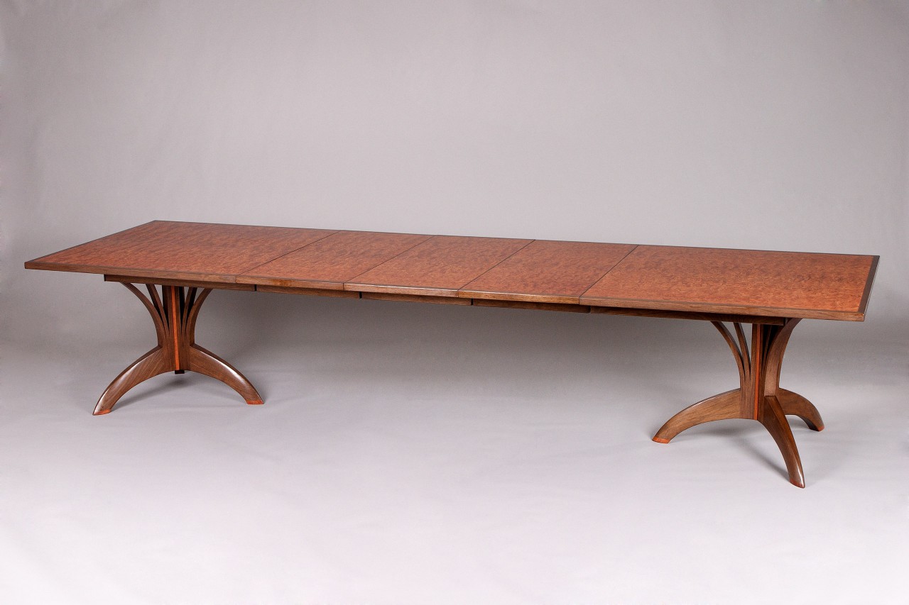 expanding dining table with leaves and custom carved base by Seth Rolland fine furniture design