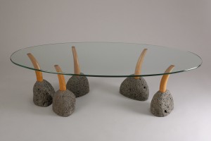 Oval glass top modern coffee table with interactive stone and wood legs by Seth Rolland custom furniture design