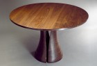 Round walnut dining table with solid carved base expands with leaves by Seth Rolland custom furniture design
