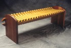 Pine and cherry wood bench with curved seat by Seth Rolland custom furniture design
