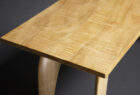 detail of top of solid maple hall table with figured top and sculpted legs by Seth Rolland Custom Furniture